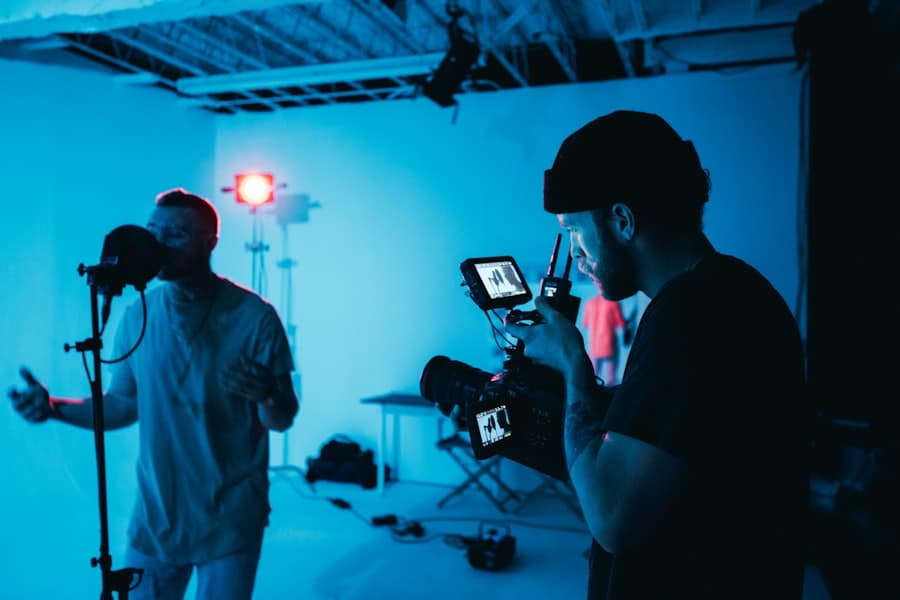 A camera operator framing a shot on a blue-lit set.